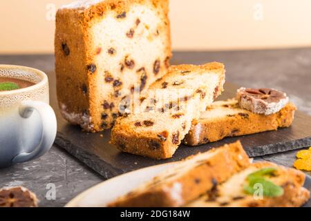 Torta fatta in casa con uvetta, persimmon secco e una tazza di cioccolata calda su fondo nero di cemento. Vista laterale, primo piano, spazio per la copia, focu selettivo Foto Stock