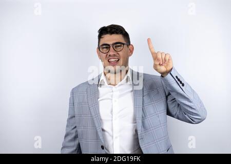 Uomo giovane di affari che indossa il vestito su sfondo bianco che ha un idea Foto Stock