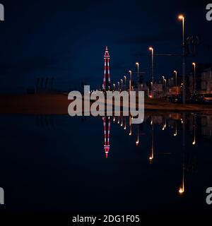 La Blackpool Tower si illuminava di notte e si rifletteva in un grande puddle Foto Stock