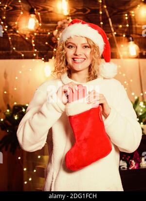 Compri o unisci la vostra calza di Natale e le stuff con i goodies  speciali. Donna tenere rosso calza. Festa di nuovo anno. Le calze riempite  con molte cose divertenti, denominate stuffers