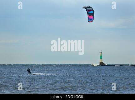 Un kite-boarder windsurf in una giornata con un faro sullo sfondo Foto Stock