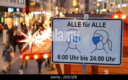 Lipsia, Germania. 07 dicembre 2020. Passers-by a piedi attraverso la zona pedonale di Grimmaische Strasse nel centro di Lipsia dietro un cartello che dice 'tutto per tutti - 6:00 a 24:00', che indica che le maschere sono obbligatorie. La pandemia della corona si sta diffondendo in modo particolarmente rapido in Sassonia. Sono quindi in vigore misure più severe, tra cui le restrizioni all'uscita. Tutti i mercatini di Natale e le tradizionali parate montane dell'Erzgebirge sono stati annullati. Credit: Jan Woitas/dpa-Zentralbild/dpa/Alamy Live News Foto Stock