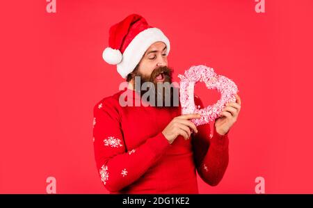 buon natale e Felice Anno Nuovo. Innamorati. Ti voglio bene. Lasciatemi sciogliere il vostro cuore. Benvenuti Natale nel vostro cuore. Bell'uomo amore inverno vacanze sfondo rosso. Il ragazzo indossa il cappello di Santa. Foto Stock