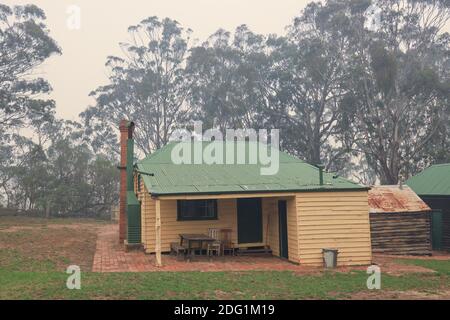 Vecchio edificio agricolo nel Nyerimilang Heritage Park avvolta nel fumo durante i fuochi d'arresto a Gippsland Est, Victoria, Australia Foto Stock