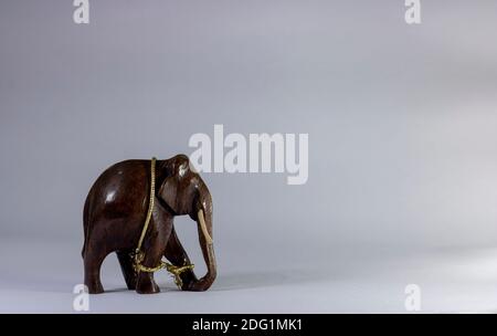 elefante in miniatura intagliato in legno su sfondo bianco Foto Stock