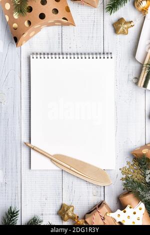 Scatole regalo di Natale e carta da imballaggio in colori oro su sfondo di legno bianco. Copiare spazio per il testo. Disposizione piatta e vista dall'alto Foto Stock