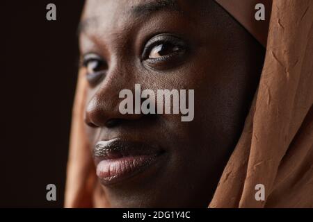 Ritratto estremo di una donna etnia afroamericana che indossa un copricapo e guardare via mentre si posa in studio Foto Stock