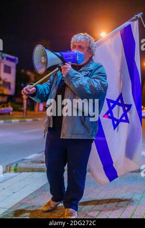 Haifa, Israele - 05 dicembre 2020: Protestante con bandiera e megafono partecipa alla protesta delle bandiere nere contro il governo e il primo ministro Foto Stock