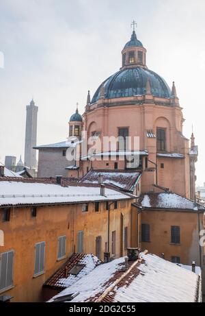 Neve sulla Chiesa e sui tetti di Santa Maria della vita, Bologna, Italia, e le torri pendenti di Garisenda e degli Asinelli Foto Stock