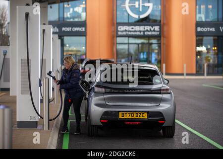 La foto del 2020 dicembre mostra un conducente che carica la sua auto al primo piazzale elettrico del Regno Unito a Braintree, Essex, che è ora completato e sarà aperto lunedì 7 dicembre. Il primo piazzale elettrico del Regno Unito si è aperto oggi – con la possibilità di caricare le auto in soli 20 minuti. Il sito in Braintree, Essex, è il primo di circa 100 previsioni elettriche da costruire intorno al paese nei prossimi cinque anni come parte di un programma di £1 miliardo. Era prevista l'apertura nel mese di novembre, ma è stata ritardata a causa della pandemia del coronavirus e del secondo blocco nazionale. Foto Stock