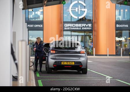 La foto del 2020 dicembre mostra un conducente che carica la sua auto al primo piazzale elettrico del Regno Unito a Braintree, Essex, che è ora completato e sarà aperto lunedì 7 dicembre. Il primo piazzale elettrico del Regno Unito si è aperto oggi – con la possibilità di caricare le auto in soli 20 minuti. Il sito in Braintree, Essex, è il primo di circa 100 previsioni elettriche da costruire intorno al paese nei prossimi cinque anni come parte di un programma di £1 miliardo. Era prevista l'apertura nel mese di novembre, ma è stata ritardata a causa della pandemia del coronavirus e del secondo blocco nazionale. Foto Stock