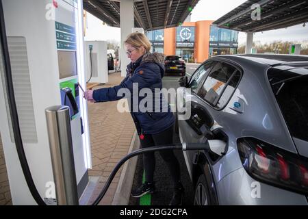 La foto del 2020 dicembre mostra un conducente che carica la sua auto al primo piazzale elettrico del Regno Unito a Braintree, Essex, che è ora completato e sarà aperto lunedì 7 dicembre. Il primo piazzale elettrico del Regno Unito si è aperto oggi – con la possibilità di caricare le auto in soli 20 minuti. Il sito in Braintree, Essex, è il primo di circa 100 previsioni elettriche da costruire intorno al paese nei prossimi cinque anni come parte di un programma di £1 miliardo. Era prevista l'apertura nel mese di novembre, ma è stata ritardata a causa della pandemia del coronavirus e del secondo blocco nazionale. Foto Stock