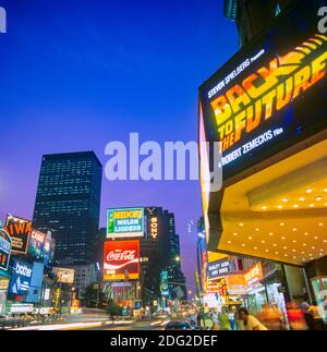 New York 1985, Times Square al crepuscolo, insegne pubblicitarie illuminate, cinema marquee, ritorno al futuro spot cinematografico, People, Midtown Manhattan, New York City, NY, NYC, STATI UNITI, Foto Stock