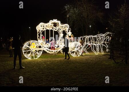 Città Ogre, Lettonia. Illuminato carro d'oro e persone.6.12.2020 Foto Stock