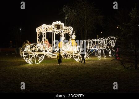 Città Ogre, Lettonia. Illuminato carro d'oro e persone.6.12.2020 Foto Stock