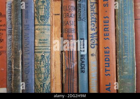 Una collezione di libri antichi, colorati e in tessuto per bambini sulla scrivania dell'insegnante presso la Surry Village School restaurata. A Surry, Maine. Foto Stock