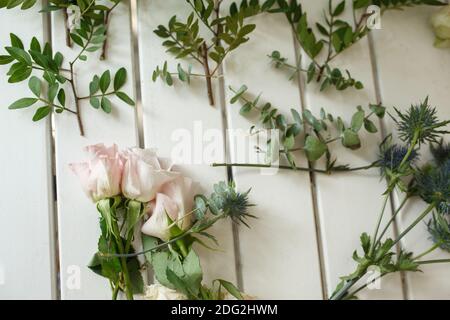 Donna fiorista mani raccoglie i fiori per lo sposo boutonniere. Evento decorazione fiori freschi. Flusso di lavoro fiorista. Design per banchetti di nozze. Foto Stock