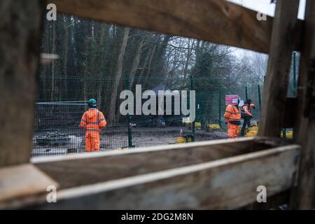 Denham, Regno Unito. 7 dicembre 2020. Le guardie di sicurezza HS2 sono viste attraverso una barricata al campo di protezione di Denham Ford. Gli attivisti anti-HS2 continuano a resistere al controverso progetto ferroviario ad alta velocità £106 miliardi di una serie di campi di protesta basati sulla sua rotta iniziale tra Londra e Birmingham. Credit: Mark Kerrison/Alamy Live News Foto Stock