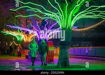 Londra, Regno Unito. 7 dicembre 2020. "Winter Light" al Southbank Centre. "Lumen", alberi illuminati da una brillante flessione al neon dell'artista David Ogle. Oltre 15 opere d'arte e nuove commissioni illuminate da una serie di importanti artisti internazionali sono presenti durante la "Winter Light", situata intorno agli edifici di Southbank e al Riverside Walk fino alla fine di febbraio 2021. Credit: Guy Corbishley/Alamy Live News Foto Stock