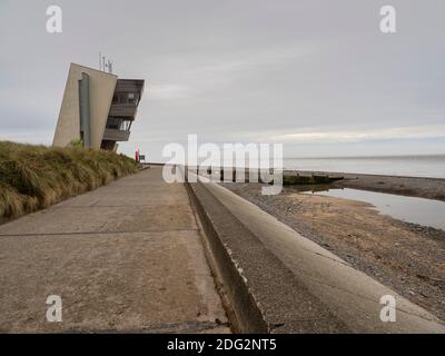 Rainbow at Rossall Beach, Fleetwood, Lancashire, Regno Unito. L'edificio a quattro piani sul lungomare esterno di Rossall Point e' la Torre dell'Orologio costiero di Rossall. Foto Stock