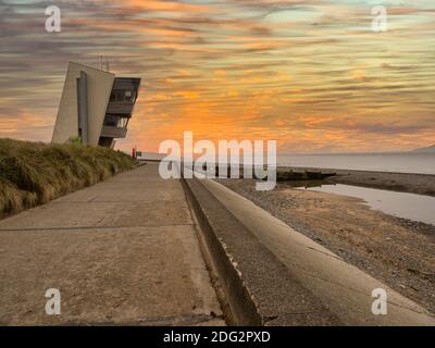 Rainbow at Rossall Beach, Fleetwood, Lancashire, Regno Unito. L'edificio a quattro piani sul lungomare esterno di Rossall Point e' la Torre dell'Orologio costiero di Rossall. Foto Stock