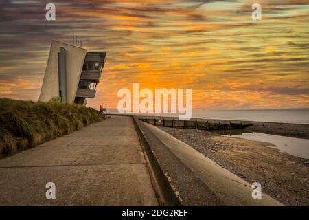 Rainbow at Rossall Beach, Fleetwood, Lancashire, Regno Unito. L'edificio a quattro piani sul lungomare esterno di Rossall Point e' la Torre dell'Orologio costiero di Rossall. Foto Stock