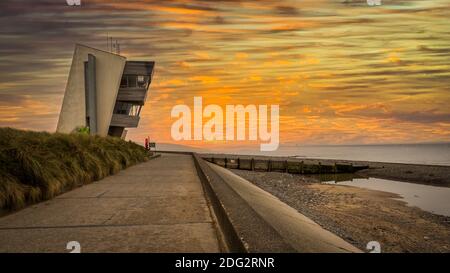 Rainbow at Rossall Beach, Fleetwood, Lancashire, Regno Unito. L'edificio a quattro piani sul lungomare esterno di Rossall Point e' la Torre dell'Orologio costiero di Rossall. Foto Stock