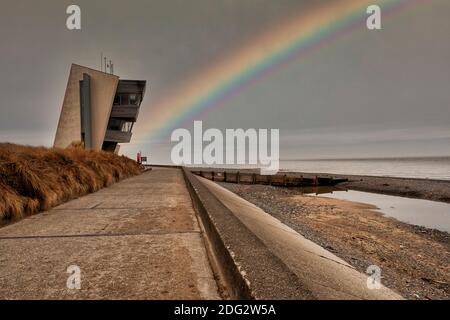 Rainbow at Rossall Beach, Fleetwood, Lancashire, Regno Unito. L'edificio a quattro piani sul lungomare esterno di Rossall Point e' la Torre dell'Orologio costiero di Rossall. Foto Stock