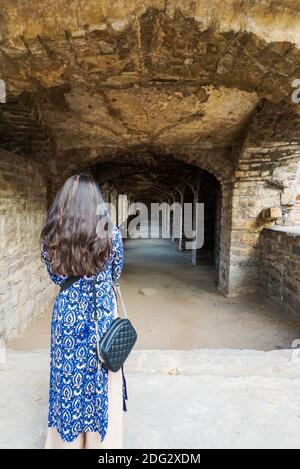 Ragazza con bei capelli colorati rivolti in lontanissima Golkonda forte di Hyderabad nello stato dell'India del sud Telangana Foto Stock