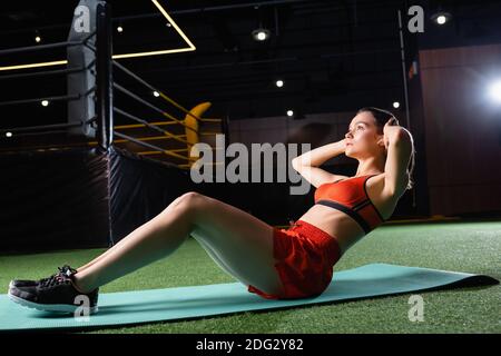 donna sportiva che fa pressione aumenta l'esercizio mentre si allenano in palestra Foto Stock