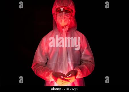 ritratto di medico maschio in tuta medica posa isolato su sfondo nero, segno di avvertimento, avvisare le persone contro il virus in tutto il mondo, covid-19 Foto Stock