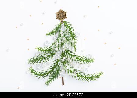 Albero di Natale fatto di rami di piante di Araucaria, decorato con fiocchi di neve dorati e perline. Foto Stock