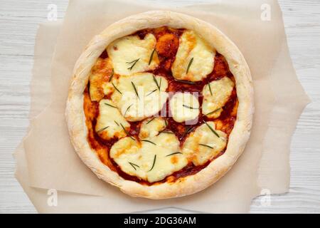 Pizza Margherita fatta in casa con mozzarella e rosmarino, vista dall'alto. Posa piatta, sovratesta, dall'alto. Foto Stock