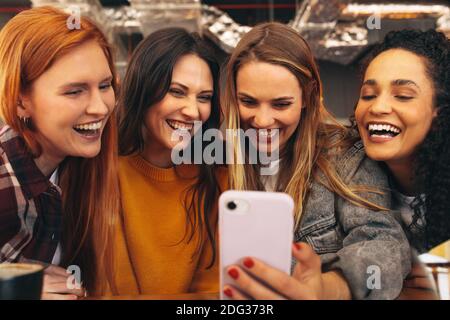 Gruppo di donne che prendono selfie al caffè. Amici di sesso femminile che prendono selfie con smartphone. Foto Stock