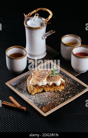 vari dessert con tè su sfondo nero Foto Stock