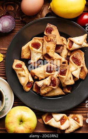 biscotti fatti in casa con marmellata di fragole su sfondo di legno Foto Stock