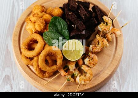 Spuntini di birra su una tavola di legno e sfondo chiaro Foto Stock