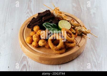 Spuntini di birra su una tavola di legno e sfondo chiaro Foto Stock
