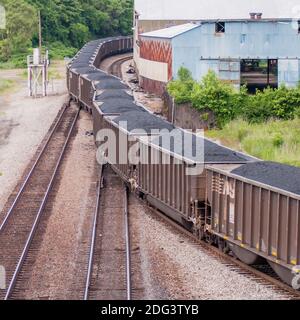 Vagoni a carbone lento su binari ferroviari Foto Stock