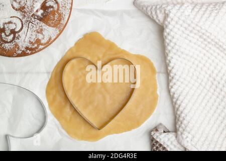 Istruzioni dettagliate per la ricetta della torta a forma di cuore. Passaggio 5. Arrotolare ogni pezzo di impasto e tagliarlo a forma di cuore. Disposizione piatta. Foto Stock