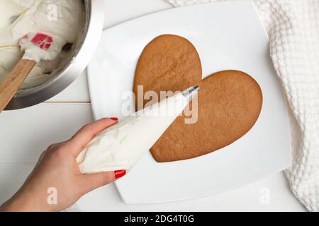 Istruzioni dettagliate per la ricetta della torta a forma di cuore. Fase 9: Mettere la panna in un sacchetto di pasticceria. Disposizione piatta. Foto Stock