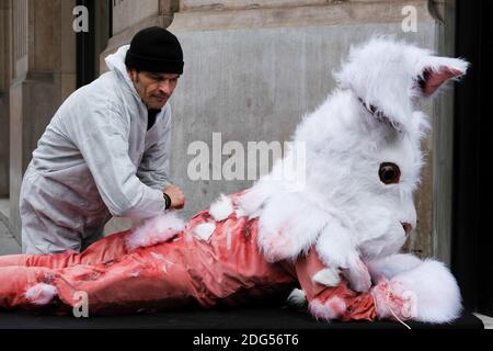 Attivisti dell'organizzazione per i diritti degli animali persone per il trattamento etico degli animali (PETA) e (One Voice) mostrano un banner che si traduce come Angora: Tortura per i conigli mentre fanno una protesta sotto forma di un'esibizione di strada che raffigura la skinning di un coniglio per la lana d'Angora a Parigi, Francia, il 9 febbraio 2017. Foto di Marie Hubert Psaita/ABACAPRESS.COM Foto Stock