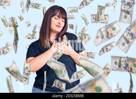 Giovane donna di taglia più indossa abiti casual sorridente con le mani sul petto con gli occhi chiusi e gesto grato sul viso. Concetto di salute. Foto Stock