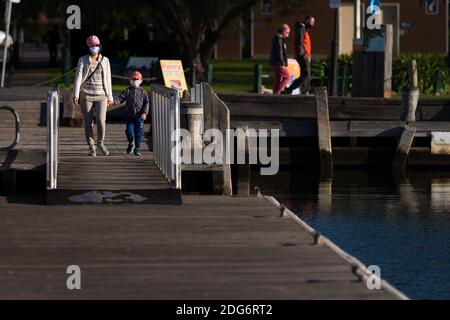 Melbourne, Australia, 16 agosto 2020. Una madre che indossa una maschera cammina con suo figlio su uno dei moli di Williamstown durante il COVID-19 a Melbourne, Australia. Victoria ha registrato 16 decessi correlati a COVID e altri 279 nuovi casi durante la notte. Ciò viene in mezzo alla speculazione che i blocchi saranno estesi e Victoria regionale può guardare a ulteriori restrizioni oltre la fase 3.Credit: Dave Hewison/Alamy Live News Foto Stock