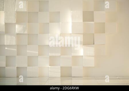 Dipinto di bianco muro di cemento fatta di cubetti con pavimento piastrellato Foto Stock