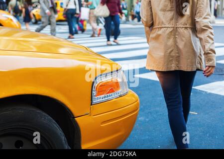 Taxi giallo in attesa ad un passaggio pedonale per attraversare le persone a Manhattan, New York City Foto Stock