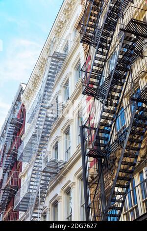 Vecchi edifici residenziali con scale di fuga dal fuoco a Soho, New York City Foto Stock