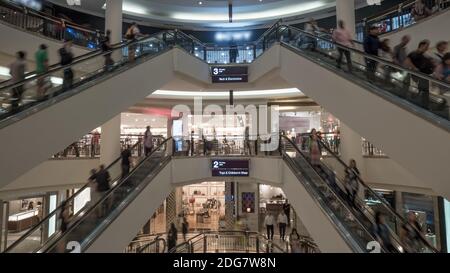 Persone su scale mobili nel centro commerciale Foto Stock