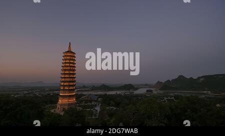 Bai Dinh Tempio con torre illuminata nel crepuscolo, Vietnam Foto Stock