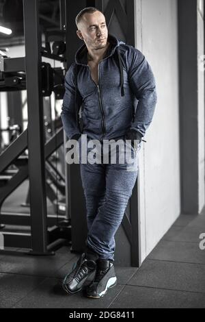 Uomo muscolare in posa nella palestra Foto Stock